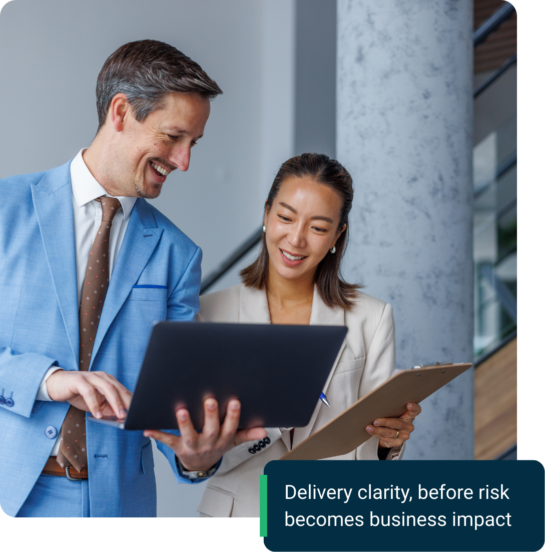 Two colleagues collaborating on a project, looking at laptop screen.