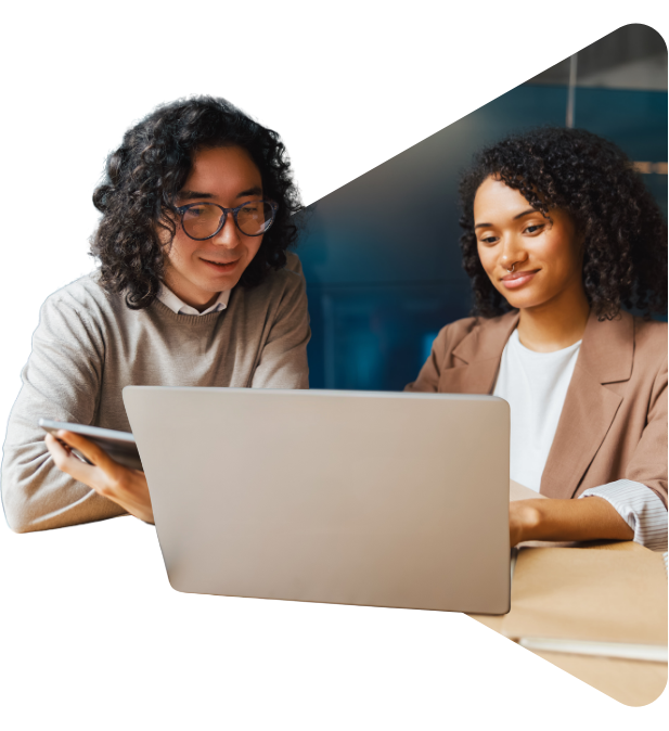 Two colleagues collaborating on a project, looking at laptop screen.