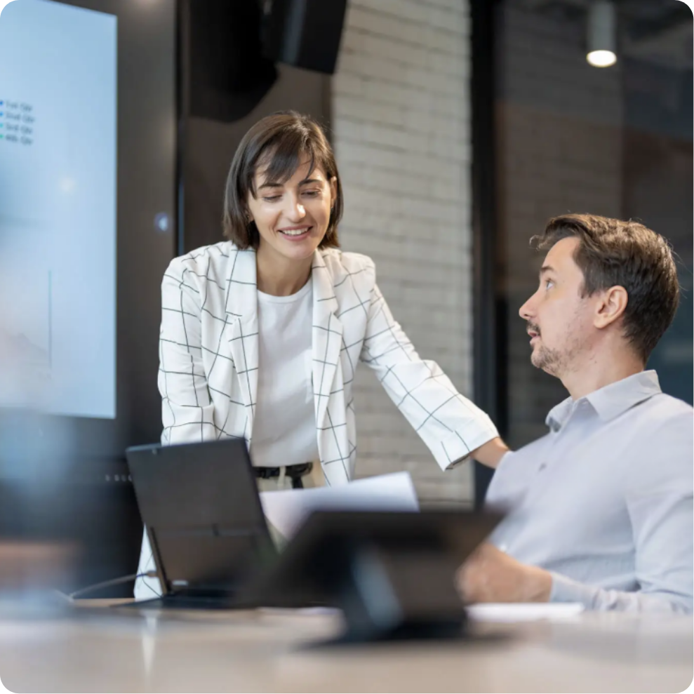 Two colleagues collaborating on a project, looking at laptop screen.