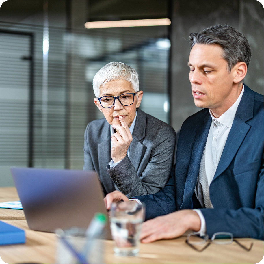 Two colleagues collaborating on a project, looking at laptop screen.