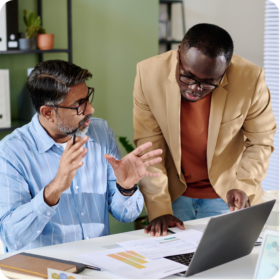 Two colleagues collaborating on a project, looking at laptop screen.