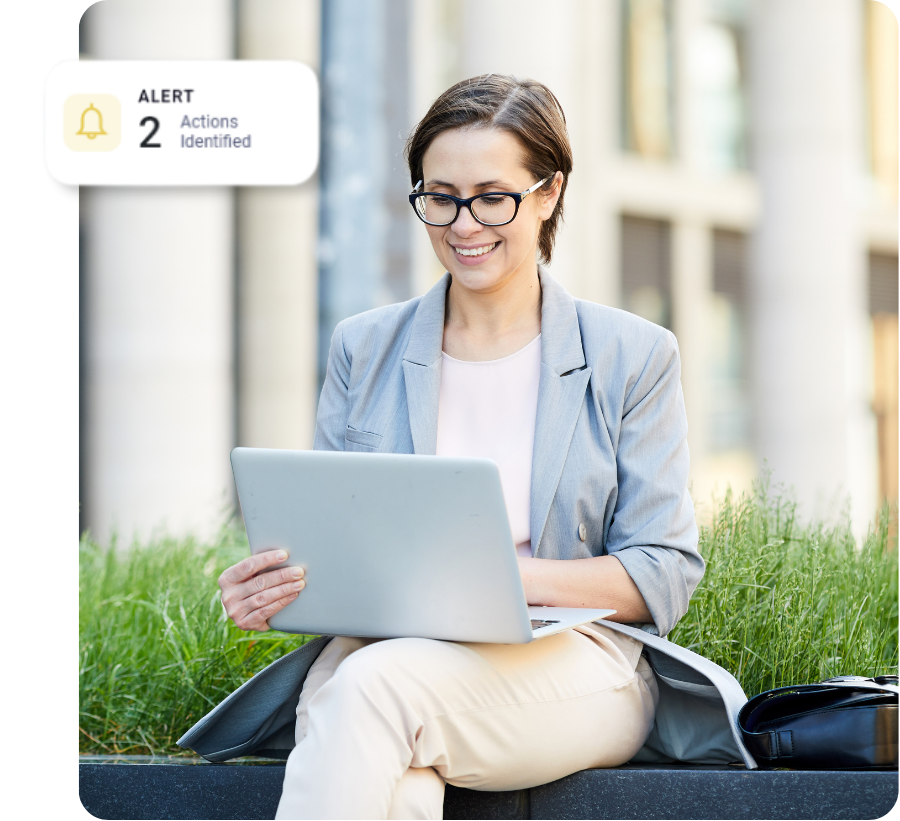 Professional sitting outside with a laptop on her lap.